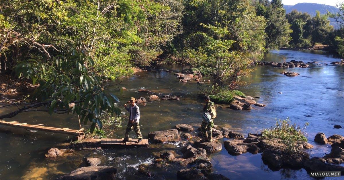 3636656|男士穿越在小溪,, 岩石, 树木河边的4KCC0视频素材插图