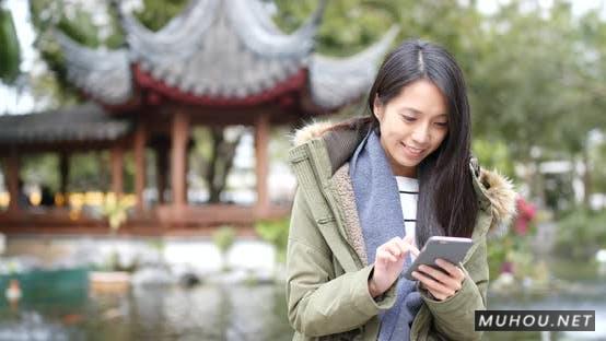 中国女性在冬季使用手机4K视频素材Woman use of mobile phone in china at winter time插图