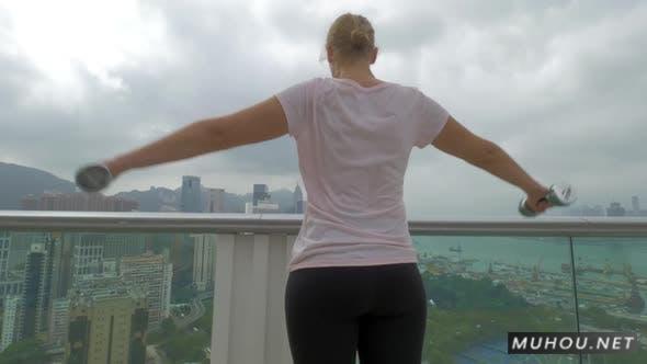 女人在阳台上做肩部练习实拍视频素材Woman Doing Shoulder Exercises on the Balcony. Hong Kong, China插图
