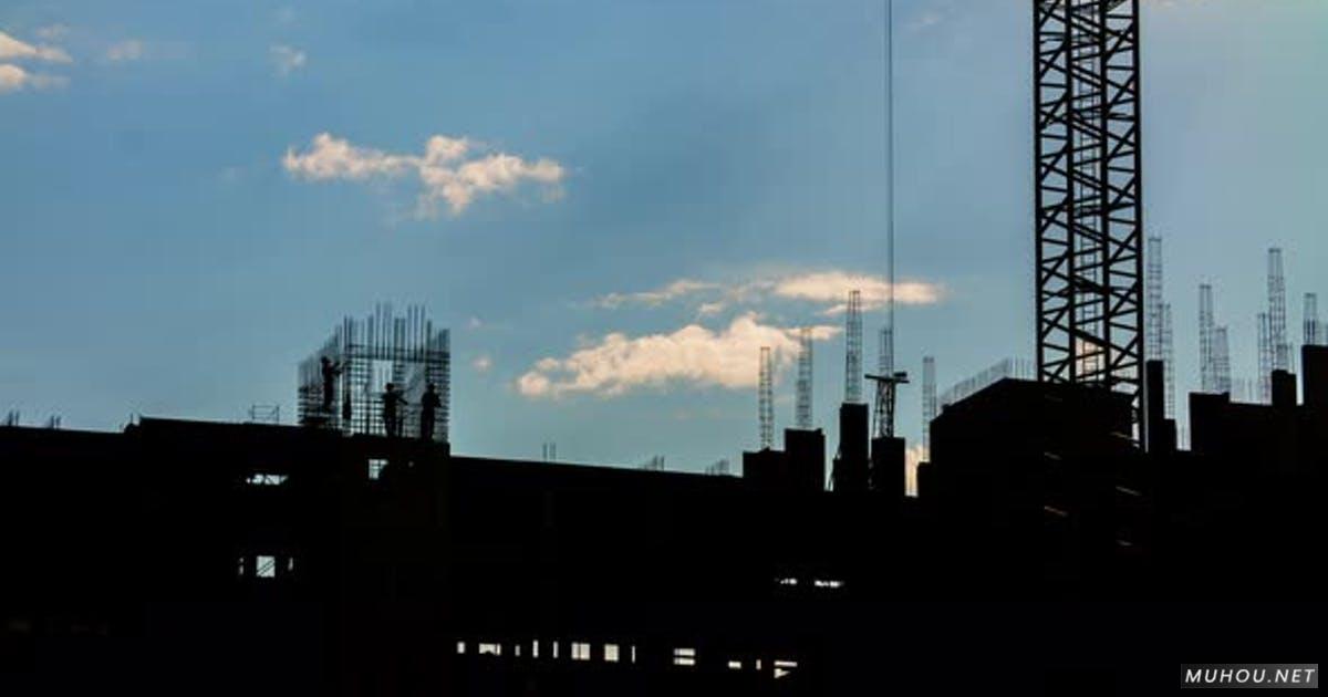 建筑工人与塔式起重机在工地工作的剪影蓝天背景4k视频素材