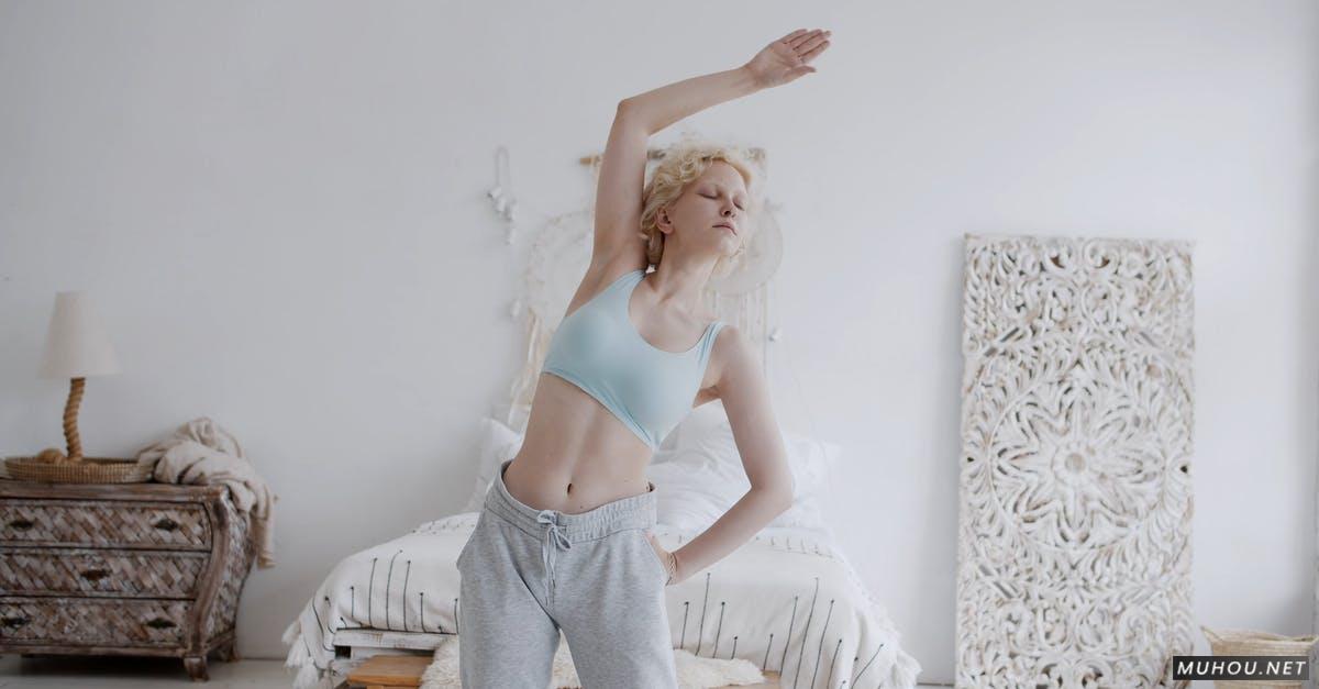 运动内衣伸展她的身体和手臂的女人4k免版权视频素材插图