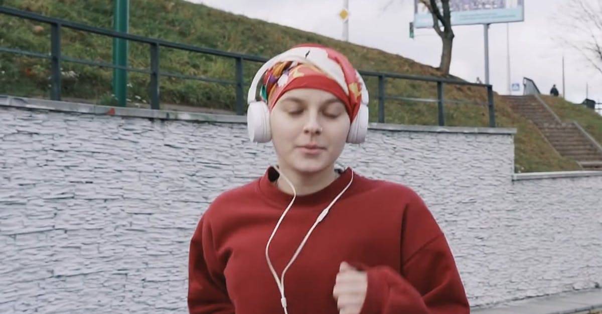 女人戴着耳机在湖边慢跑竖屏高清CC0视频素材
