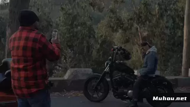 一名男子为他的朋友在摩托车上摆姿势拍照视频素材
