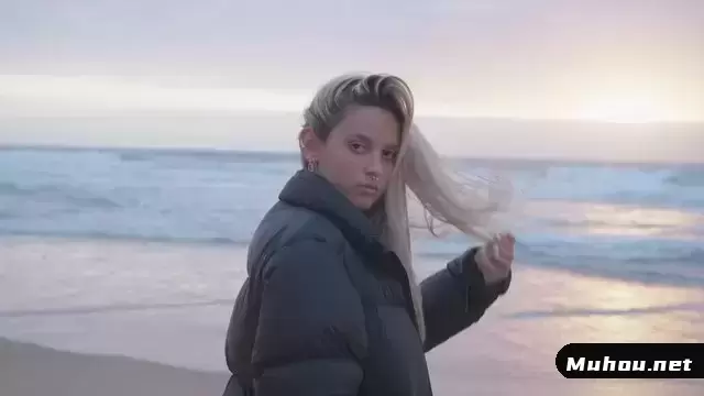 日落时在海滩上摆姿势的女孩视频素材插图