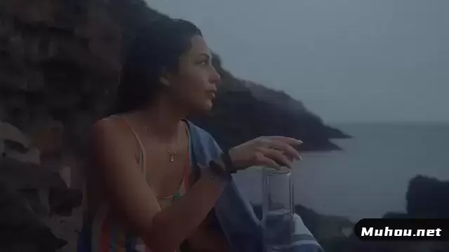 一个女孩坐在沙滩上喝水视频素材