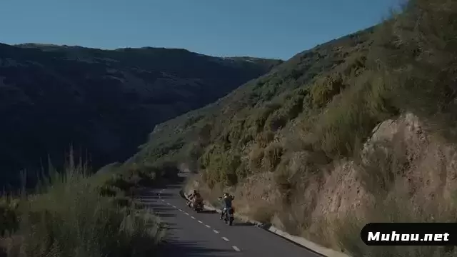 骑摩托车的人沿着弯曲的道路行驶视频素材