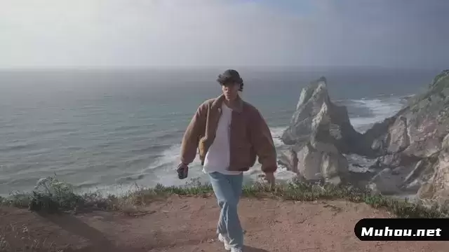 一个卷发的家伙在悬崖边散步时挥手告别视频素材插图