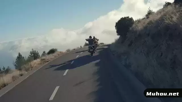 两名骑自行车的人正驶过道路上的上坡弯道视频素材
