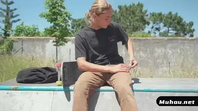 金发滑板手坐在坡道上时使用智能手机视频素材
