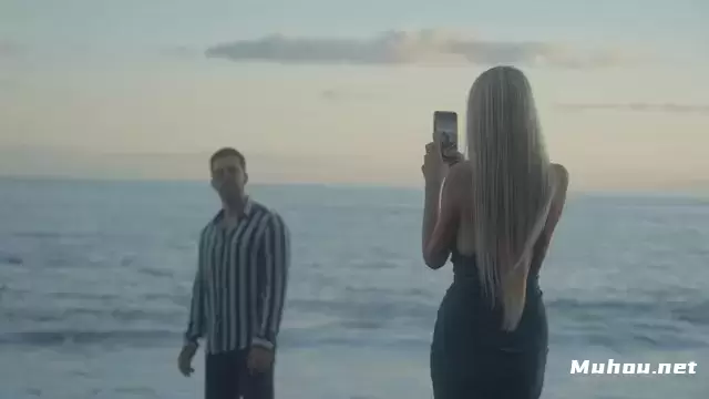 一个女人在海滩上给她的男朋友拍照视频素材