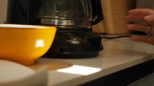 女人按下咖啡机上的电源按钮视频素材