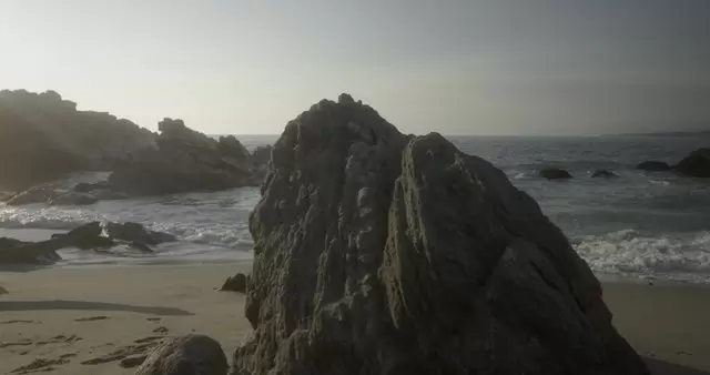 海滩上的一块大石头和日落镜头视频素材