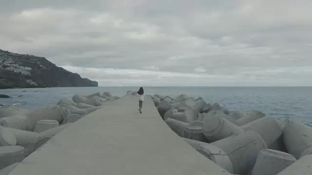 在海洋附近奔跑的女人背影航拍视频素材