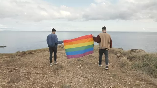 同性恋夫妇举着骄傲的旗帜航拍视频素材